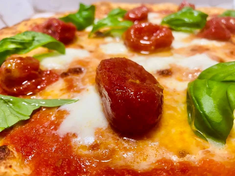 Pizza margherita con pomodorini e basilico fresco